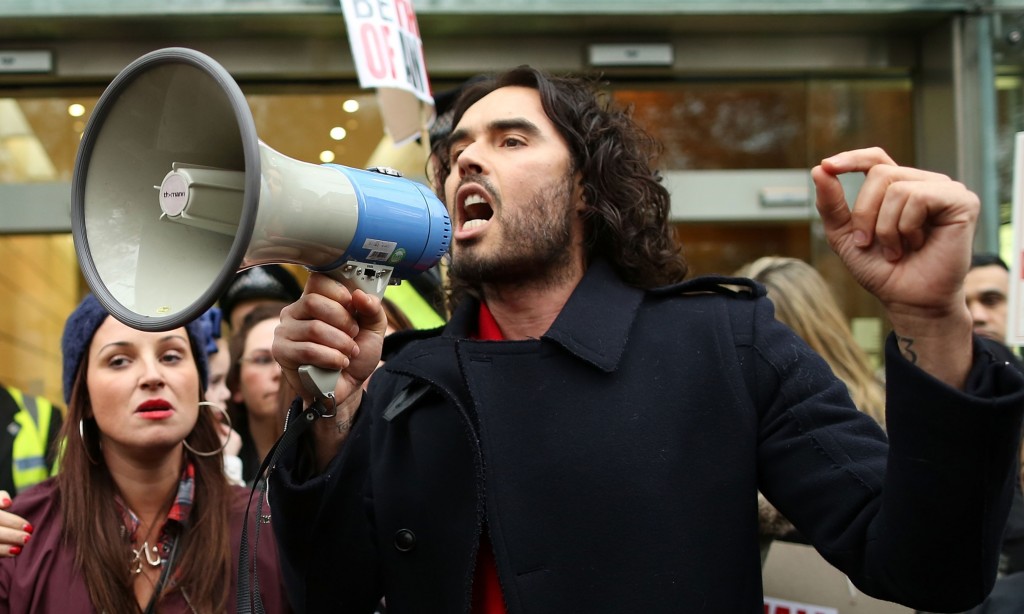 LONDON, ENGLAND - DECEMBER 01: Comedian Russell Brand joins residents and supporters from the New Era housing estate in East London as they demonstrate against US investment company Westbrooks plans to evict 93 families on December 1, 2014 in London, England. The protestors have taken their demonstration to Westbrooks Headquarters in Mayfair and plan to present a petition to the Prime Minister. WestBrooks are said to be planning to evict the tenants, refurbish the estate and re-let the flats at full market value. (Photo by Dan Kitwood/Getty Images)